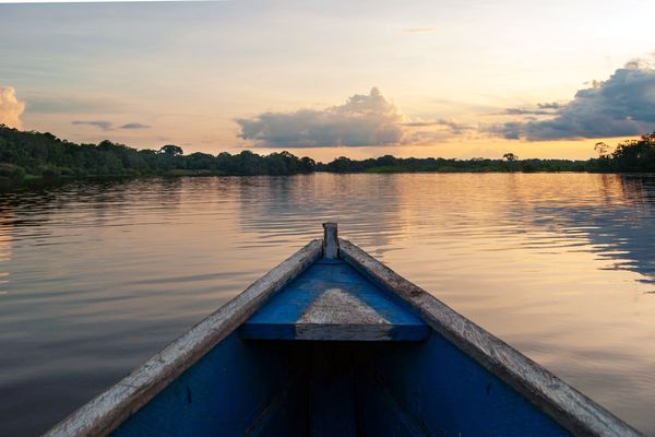 A wooden canoe on the Amazon at sunrise