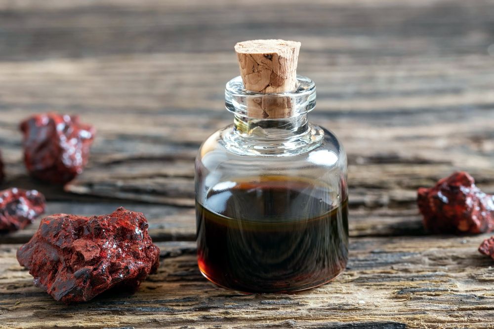 Pieces of dried tree resin beside a small bottle of oil